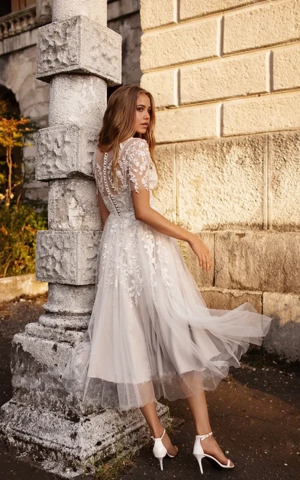 Vestido de novia de corte A, escote en V, mangas cortas, espalda con botones y corte etéreo